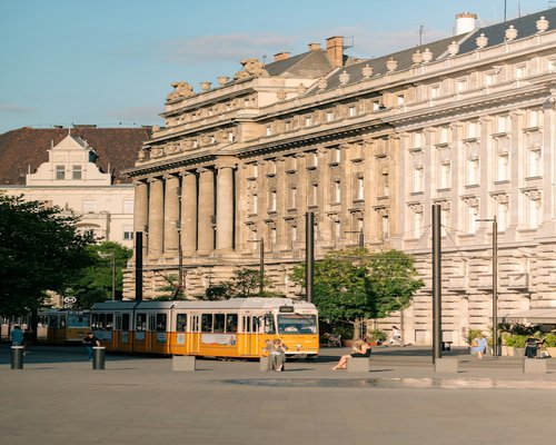 Blurry view of busy commuters waiting for a yellow tram in a European city